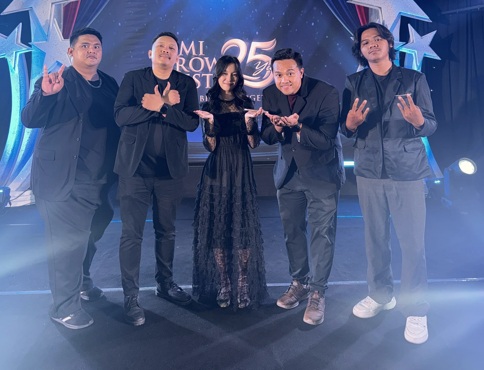 Lima personel Radiobox berpose santai bersama di panggung
